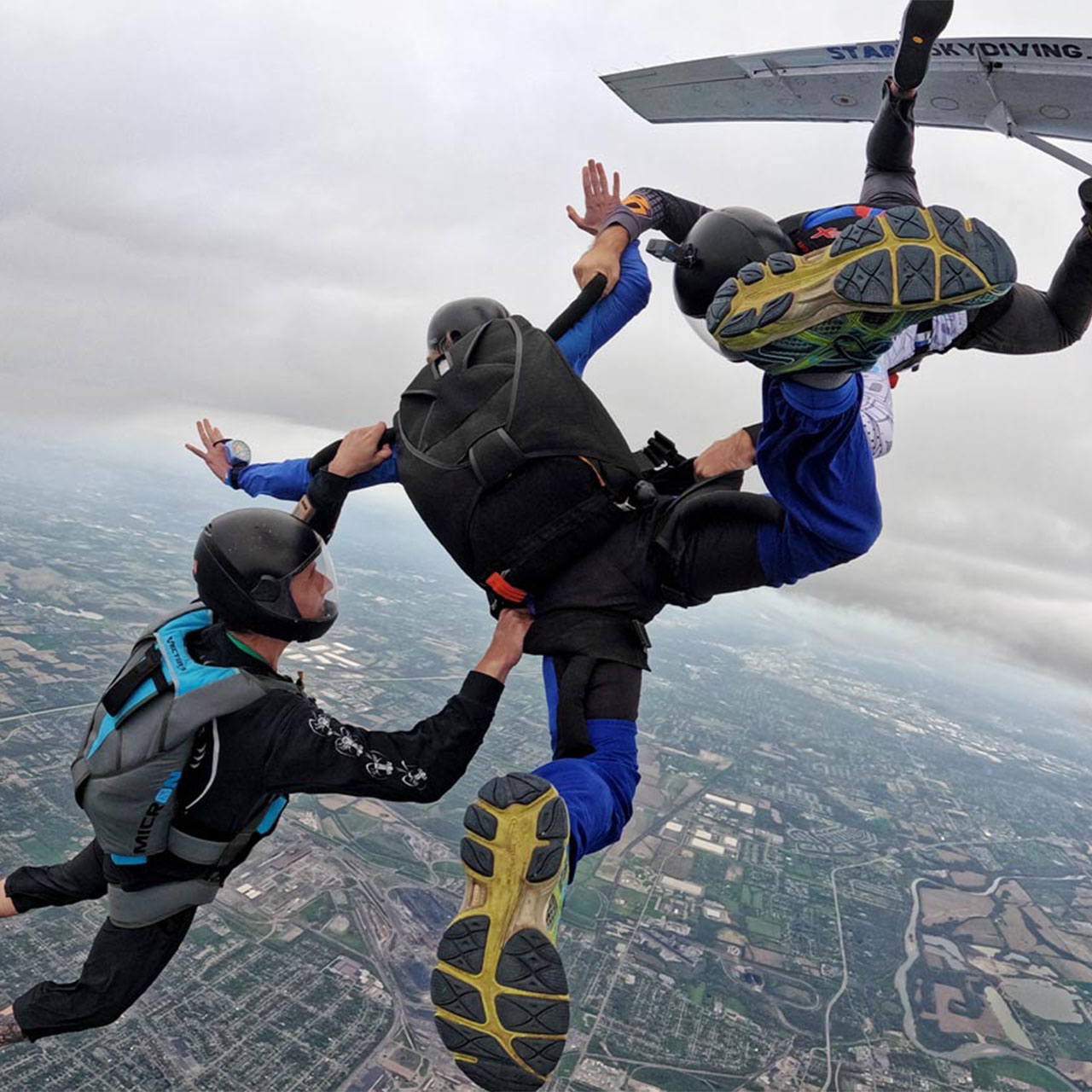 A learn to skydive AFF jumper and his two instructors exiting from the aircraft.