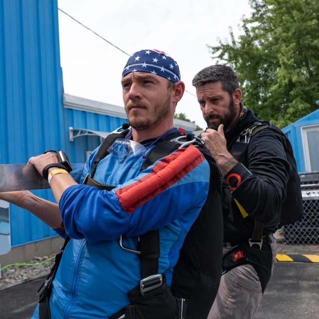 Learn to skydive student and his instructor prepare for an airplane exit by practicing on a mockup on the ground.